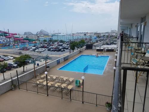 怀尔德伍德海滩露台汽车旅馆的一座带停车场的建筑阳台上的游泳池
