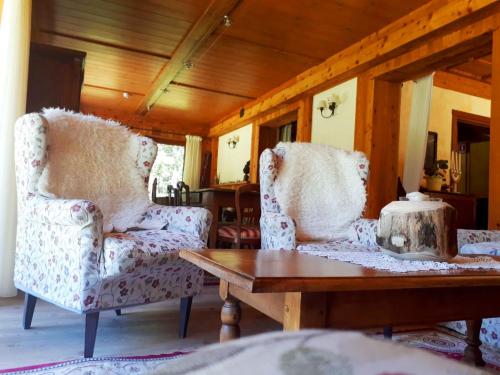 尚波吕克乐罗酒店的客厅配有两把椅子和一张桌子