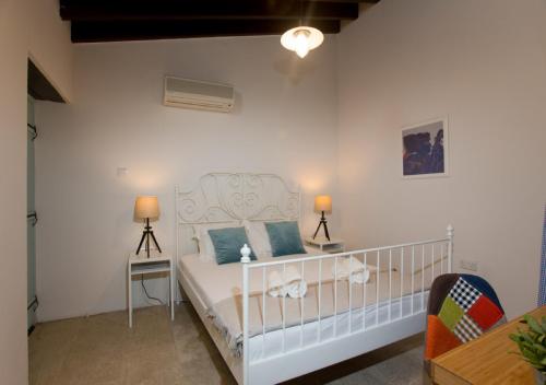DheriniaShongas Inn的一间卧室配有白色床和蓝色枕头