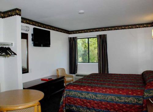 马纳萨斯时尚之家旅馆的酒店客房配有一张床铺和一张桌子。