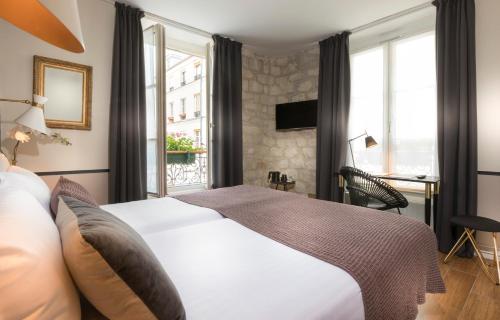 巴黎玛莱斯圣女贞德酒店的酒店客房设有床和窗户。