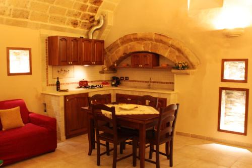 奥里亚Casetta Donnolo的厨房配有桌子和红色沙发