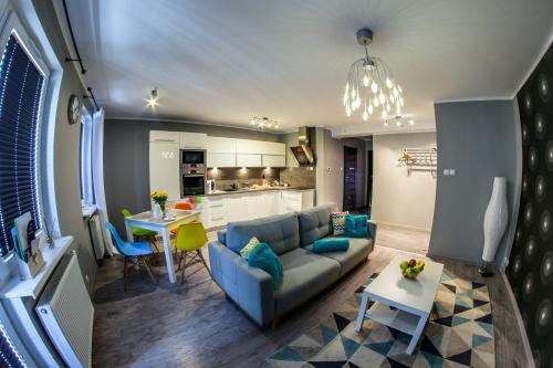 科沙林中心公寓的一间带蓝色沙发的客厅和一间厨房