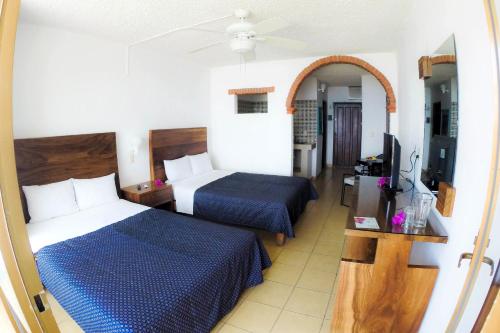 瓜亚比托斯科斯塔阿莱格里酒店及套房的酒店客房设有两张床和电视。
