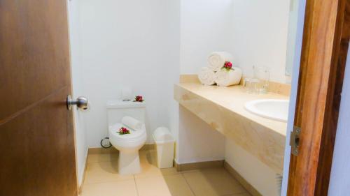 瓜亚比托斯科斯塔阿莱格里酒店及套房的白色的浴室设有卫生间和水槽。