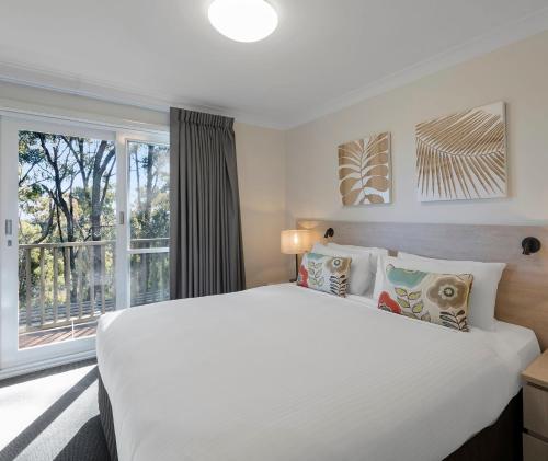 波高尔宾赛普拉斯湖盛橡度假酒店的卧室设有一张白色大床和一扇窗户。