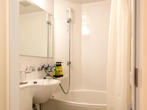 热海TKP 热海桃山温泉酒店的白色的浴室设有水槽和淋浴。