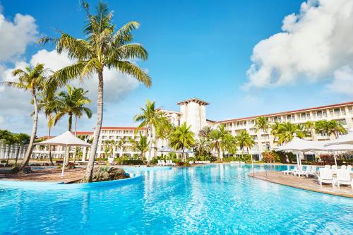 与那关岛莱昂广场度假酒店的棕榈树度假村前的游泳池