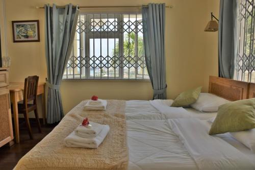 维多利亚贝尔艾尔酒店的一间卧室配有两张床、毛巾和窗户