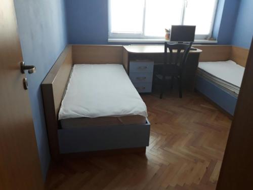 普列文Apartment ILIEVI的小房间设有一张床和一张带电脑的书桌