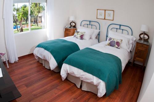 派桑杜帕皮罗斯酒店的卧室内的两张带绿色和白色床罩的床