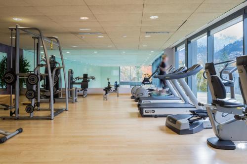 安道尔城安道​​尔公园酒店的带有跑步机的健身房和有背景的女性