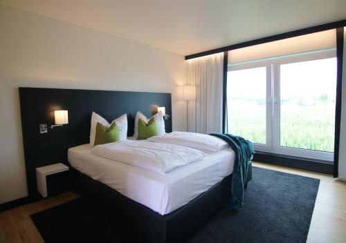 明德尔海姆MN Hotel by WMM Hotels的一间卧室设有一张大床和大窗户