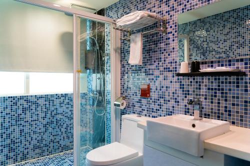 台北東驛商務旅館的蓝色瓷砖浴室设有水槽和淋浴