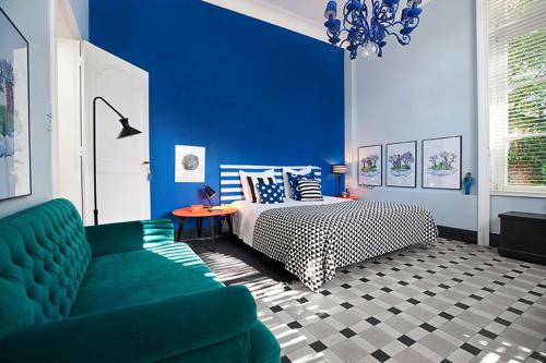 阿斯克新城Queen Christine的蓝色卧室,配有床和绿色沙发