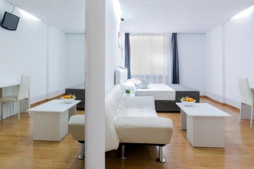 马德里Boutique Urban Madrid Serrano的白色的客房配有床、椅子和桌子
