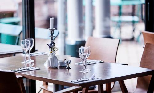 克里斯蒂安斯塔德Araslöv Golf & Resort的一张带酒杯的木桌和蜡烛