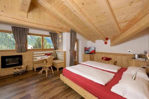 博萨迪法萨Hotel Garni Lastei的一间卧室配有一张大床和一张书桌