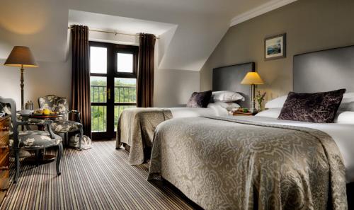 基拉尼Killarney Heights Hotel的酒店客房设有两张床和窗户。
