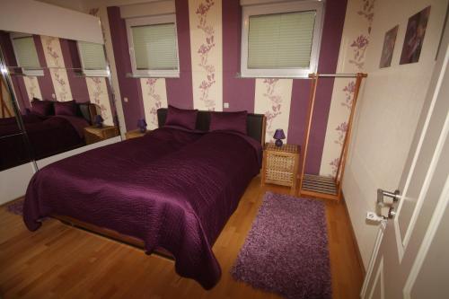 埃森鲁尔多米兹尔度假屋的一间卧室配有紫色床和紫色毯子
