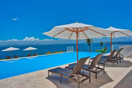 圣塔芭芭拉-山美纳萨马纳马雷克塞利特远景公寓 的一个带椅子和遮阳伞的游泳池以及大海