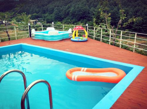 加平天马行空度假屋的一个带两个充气式泳池和一个游乐场的游泳池