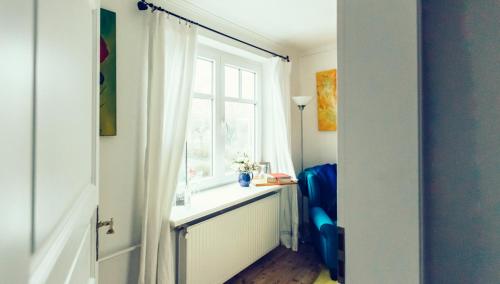 胡苏姆Das Blaue Haus的客房设有窗户和蓝椅。