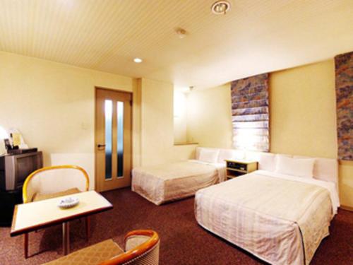 佐世保利奥广场酒店的酒店客房设有两张床和一张桌子。