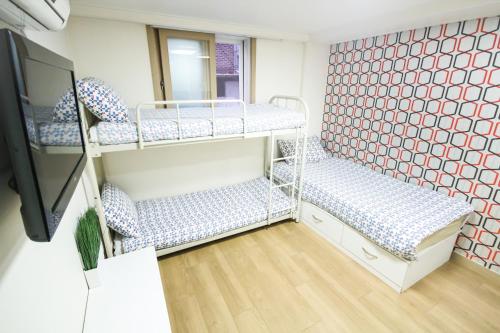 首尔首尔佳家背包客旅馆的客房设有两张双层床和镜子