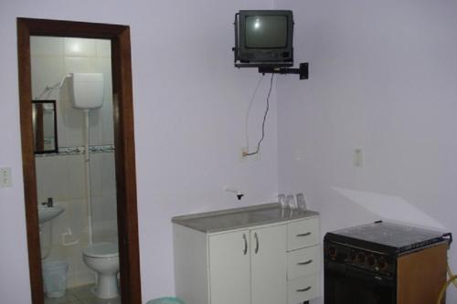 特拉曼达伊Pousada Tuiuti的一间带水槽的浴室和墙上的电视