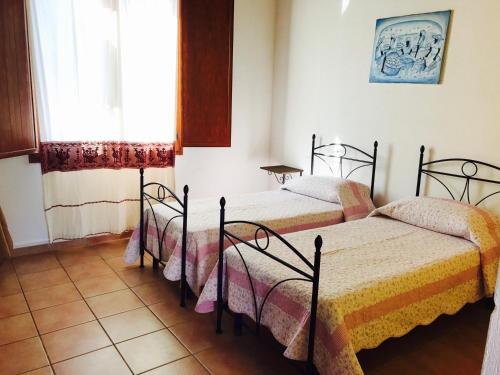 DolianovaAgriturismo Santu Marcialis的带窗户的客房内的两张床