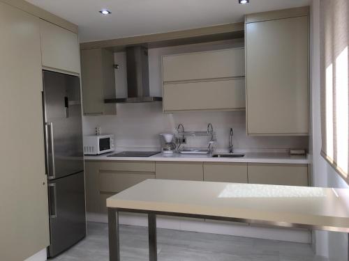 隆达新隆达公寓的厨房配有白色橱柜和桌子