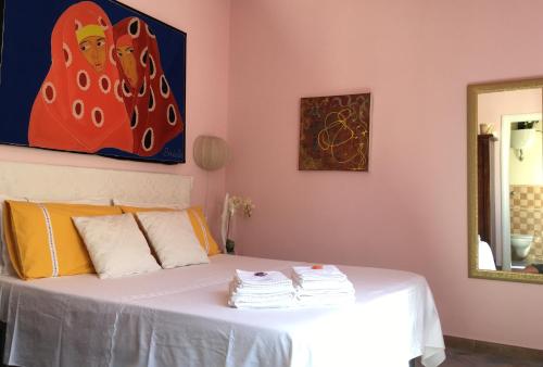 阿尔盖罗Bogamarì的卧室配有一张白色床,墙上挂有绘画作品