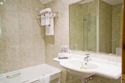 Aios奥卡维尔玛尔就对岸的浴室配有盥洗盆、镜子和浴缸