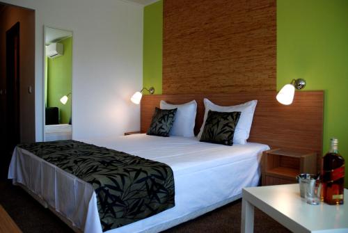希萨里亚Green Hisar Hotel Family的卧室配有白色大床和绿色墙壁