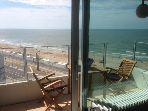 奥斯坦德Apartment Raversijde with Seaview的阳台配有两把椅子,享有海滩美景