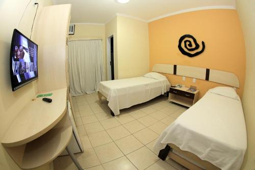 阿拉卡茹圣曼努埃尔普拉亚酒店的酒店客房设有两张床和一台平面电视。