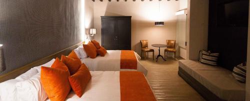 莱昂Othelo Boutique Hotel Mexico的酒店客房 - 带两张带橙色枕头的床