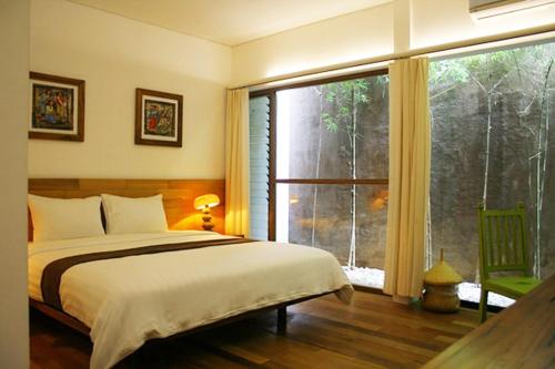 梭罗卢玛图里生态精品酒店的一间卧室设有一张床和一个大窗户