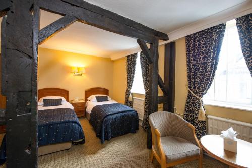 什鲁斯伯里鲁珀特王子酒店的酒店客房设有两张床和一张桌子。