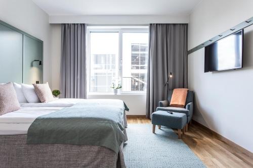 斯德哥尔摩哈马比斯约斯德公寓式酒店的一间卧室配有一张床、一把椅子和电视