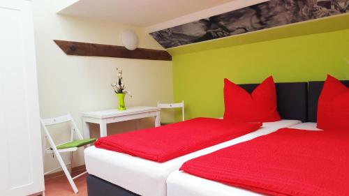 阔克威兹Radlerhof Spreewald的一间卧室配有红色枕头和绿色的墙壁
