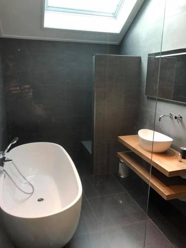 霍勒姆De beurs的浴室配有白色浴缸和水槽