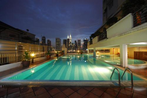吉隆坡吉隆坡假日广场公寓的一座大型游泳池,其背景是城市天际线