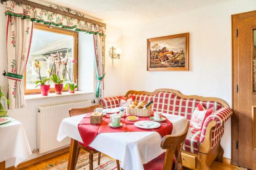 埃本瑙沃斯可古特旅馆的一间带桌子和红色及白色沙发的用餐室