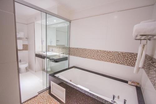 恩卡纳西翁狂欢节赌场酒店 的带浴缸、卫生间和盥洗盆的浴室