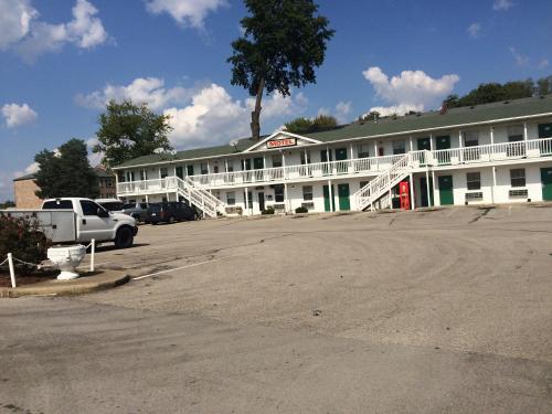 杰斐逊维尔Hoosier Travel Lodge的一座白色的建筑,前面设有停车场