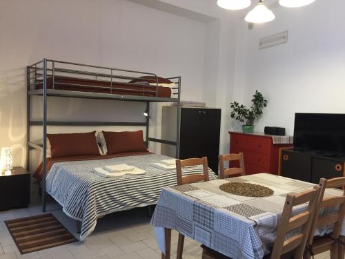 扎费拉纳-埃特内阿Casa Vacanza的一间卧室配有一张双层床和一张桌子及椅子。