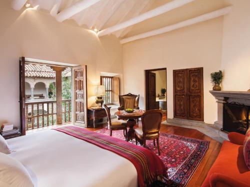 库斯科因卡特拉拉卡索纳罗莱夏朵酒店的一间卧室配有一张床、一张桌子和一个壁炉
