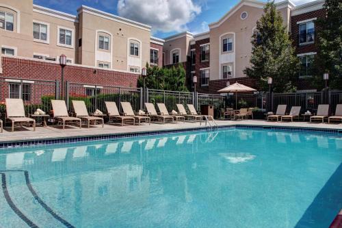 East Norriton悦府费城/普利茅斯会议酒店的一座带躺椅的游泳池和一座建筑